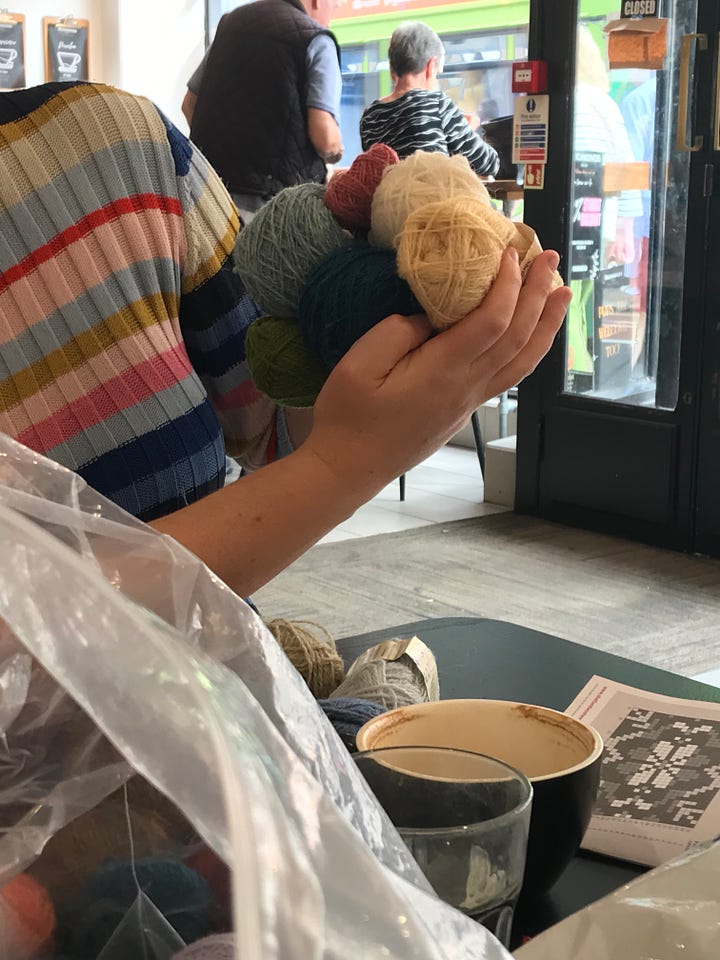 Lots of balls of Shetland wool on a table in a coffee shop