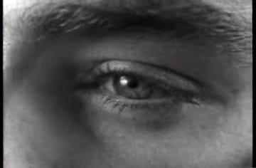 a black and white close up of a man's face and eye