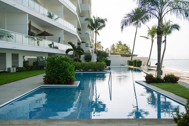 Becca and I cheers with the morning coffee,  Picture 2 infinity pool at the condo, picture 3 view of the front of the condo building from the beach, picture 4 my hat and backpack ready for the beach, 