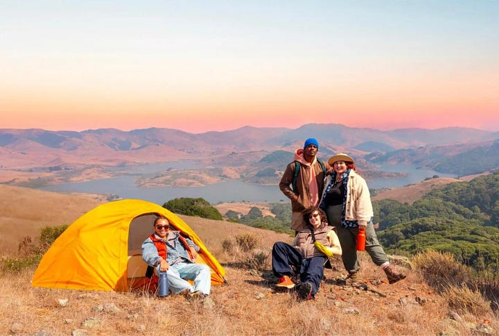 Two photos of several people at a camp site overlooking a lake. In the first photo, there's a cooler in the center of the photo, the sky is hazy blue, and the person on the left is near the edge of the photo. In the second photo, the cooler is gone, the sky is a beautiful sunset, and the person on the left has been moved to the center of the image.