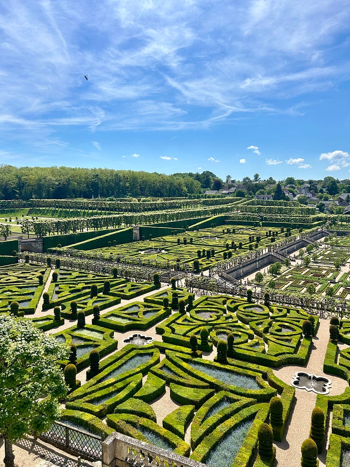 Two images of the Château de Villandry, one with the stone castle and a staircase flanking gardens, the other showing the intricate maze-like gardens all in green 