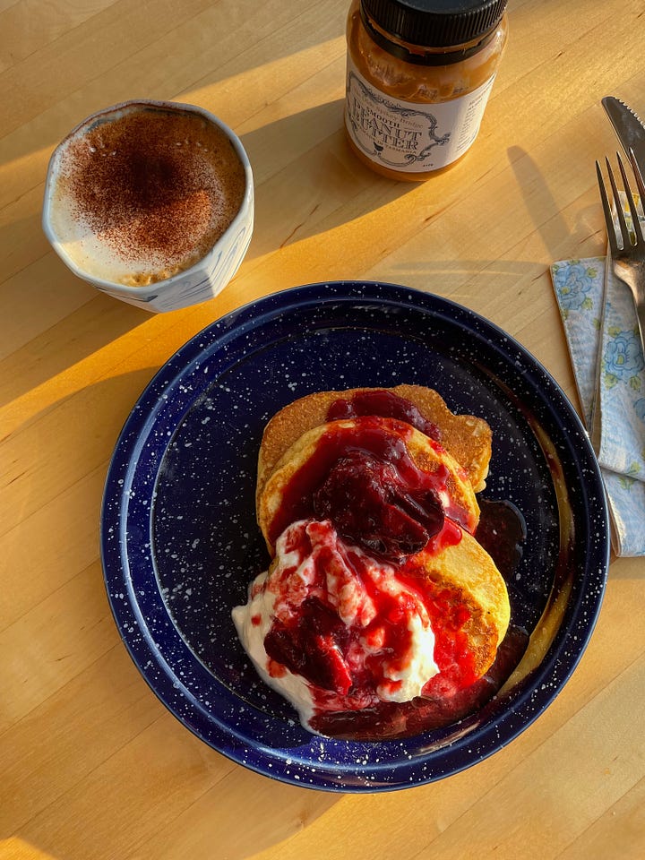 First image shows a ramen bowl with pancake ingredients like almond meal, an egg and vanilla extra. Second image is three pancakes on a speckled plate, topped with yoghurt and stewed plum, a cappuccino nearby.