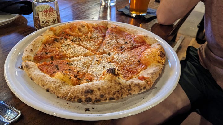 2 photos: 1 of outside the restaurant at dusk, and 1 of the vegan wood-fired marinara pie