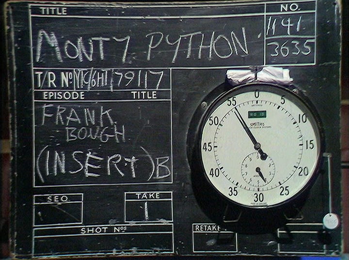 A chalkboard VT clock, followed by Michael Palin as Frank Bough looking very amused at Eric Idle's dirty joke