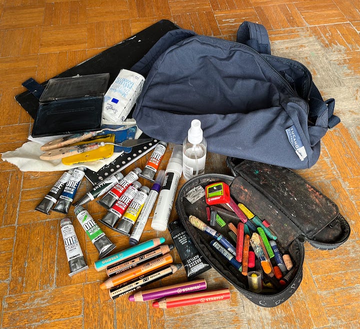 Picture of a small rucksack, paper and boards, and various art materials