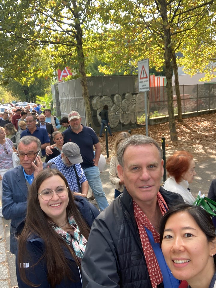 Four colourful images of people queuing to enter the Terra Madre event in Turin in 2022, and one of a large blue snail which is the logo of Slow Food.