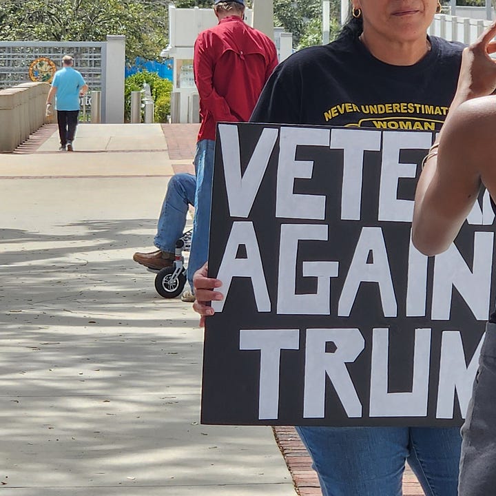 Veterans holding signs in protest of President Trump