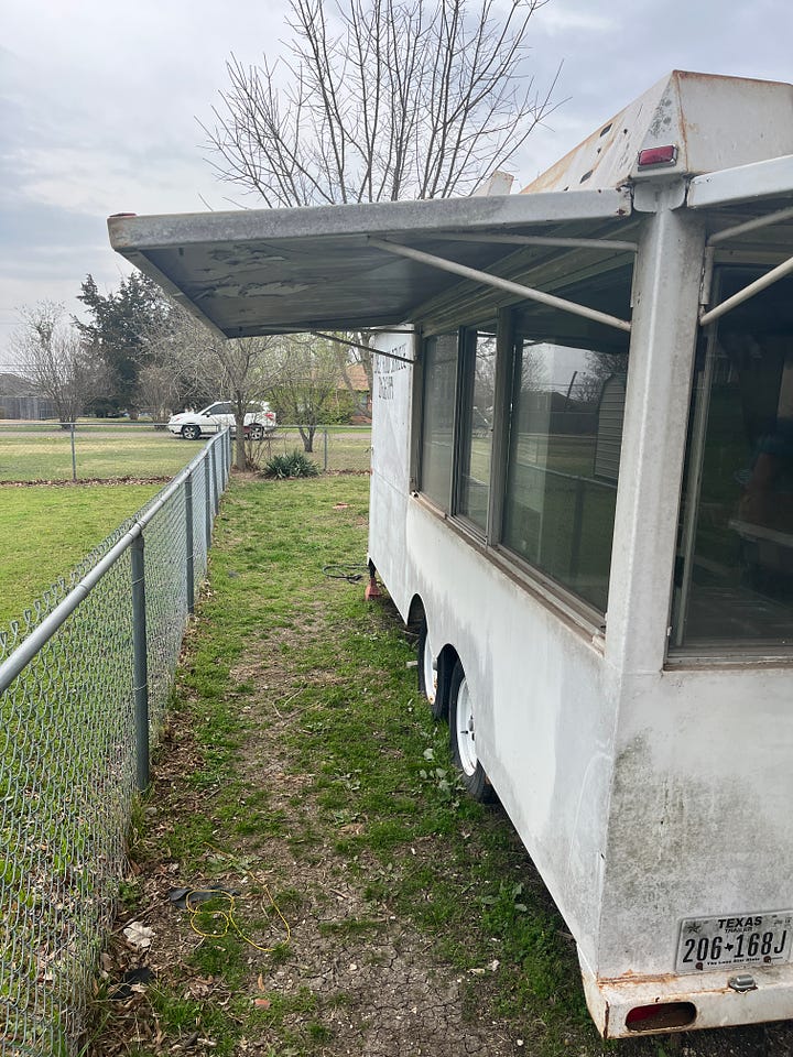 Old food trailer sitting in a backyard that was purchased by Bourbon Brothers BBQ.
