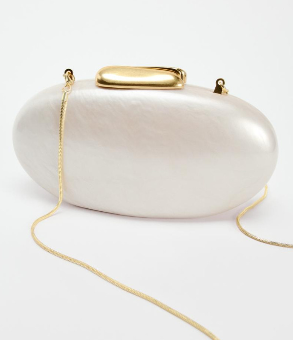 An oval shaped pearl clutch with gold accents and a brown mini shopper bag with cream colored cross-body strap attachment