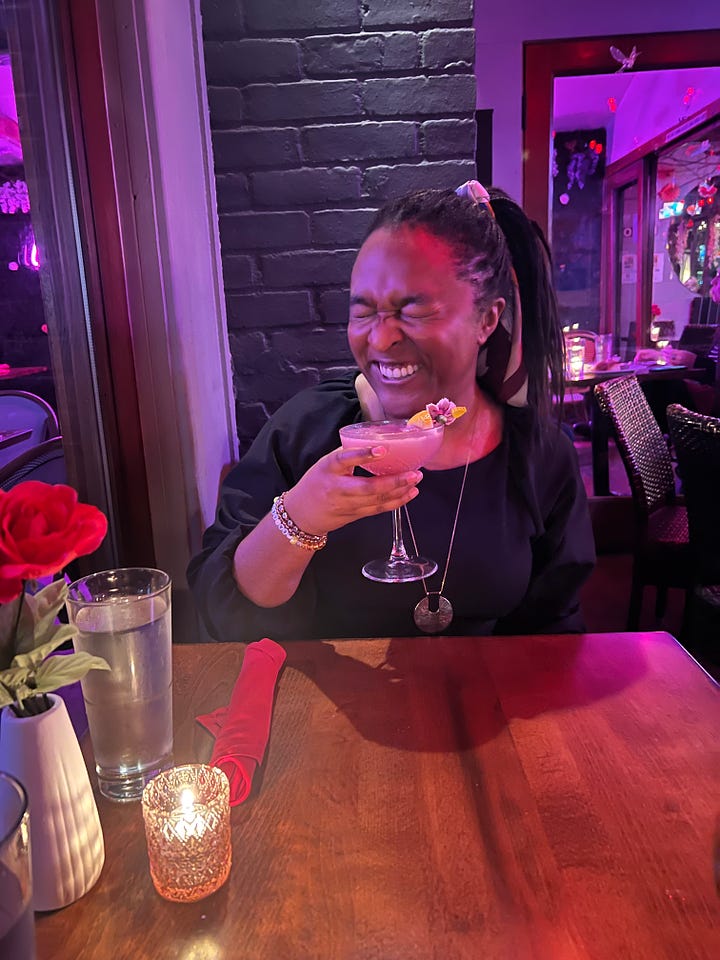 4 photos of me smiling and posing with my cocktail at a restaurant; smiling, with my eyes closed in a scrunched up face, sassily looking away from the camera, and cheers-ing to the camera while peeking out from behind the drink)