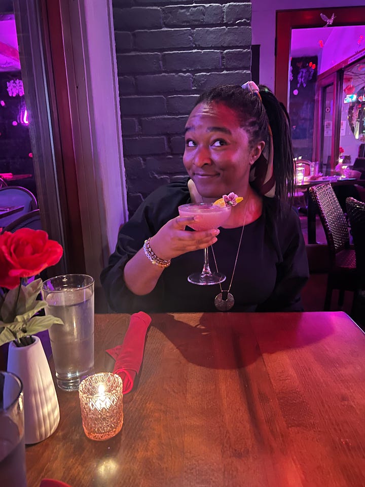 4 photos of me smiling and posing with my cocktail at a restaurant; smiling, with my eyes closed in a scrunched up face, sassily looking away from the camera, and cheers-ing to the camera while peeking out from behind the drink)