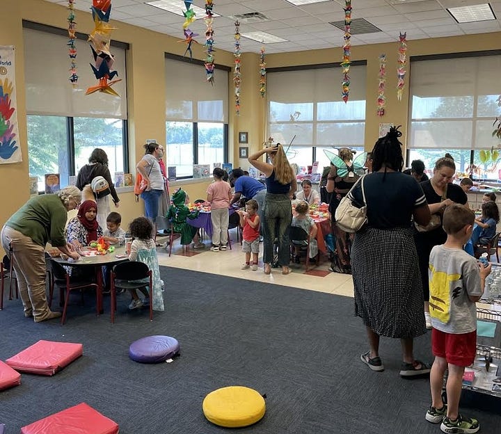 4 photos, first is author Naomi Novik on a zoom interview. Second is a person in medieval metal armor wielding an axe. Third is Marty next to a hand-made wooden wishing well. Fourth is a room of children and parents at craft time.