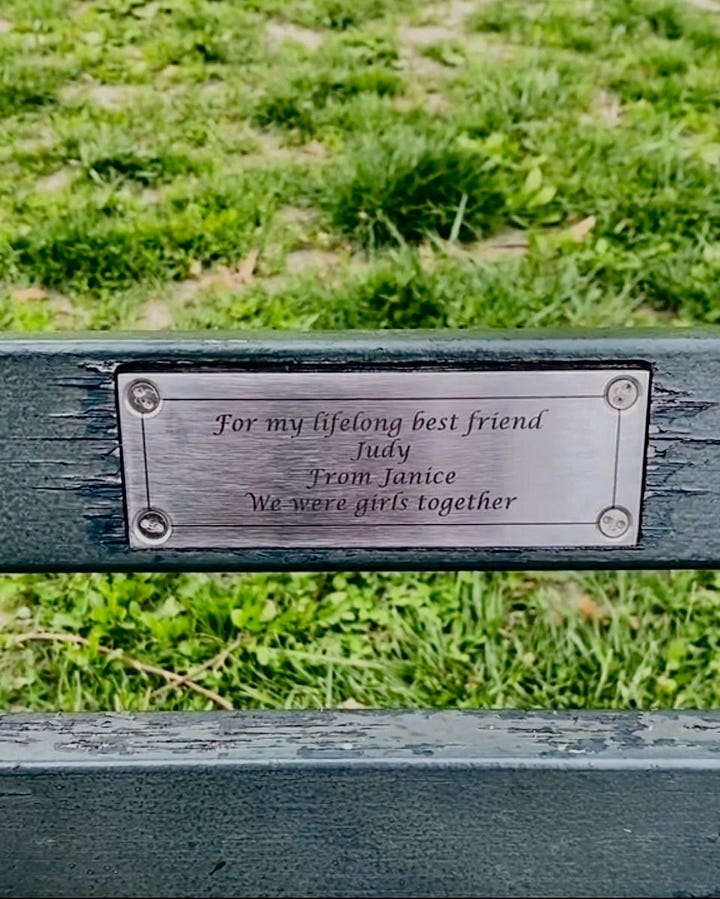 Bench with a plaque that reads "For my lifelong best friend Judy, From Janice. We were girls together."