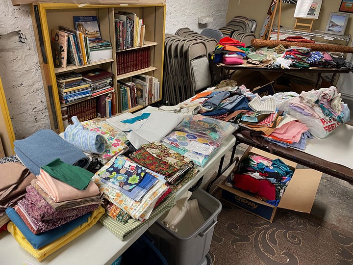 Swap tubs in a retail store, empty tables arranged in a basement, the same tables beginning to fill with materials, and a wide range of donated supplies on those tables from paint to frames.