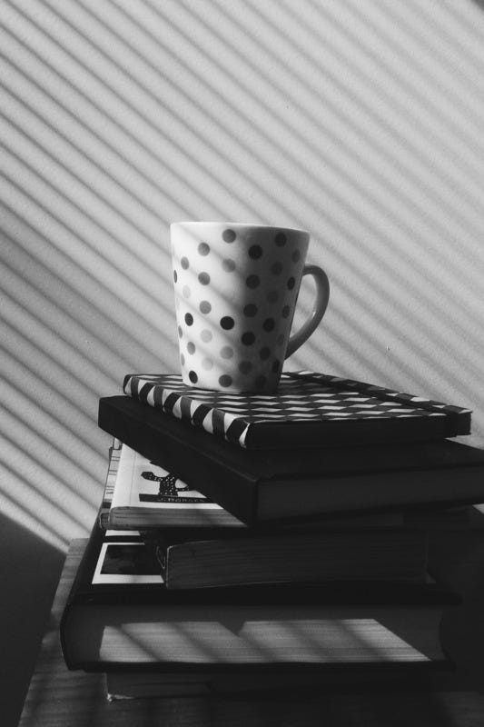 Black and white photographs of books, a teacup and pictures