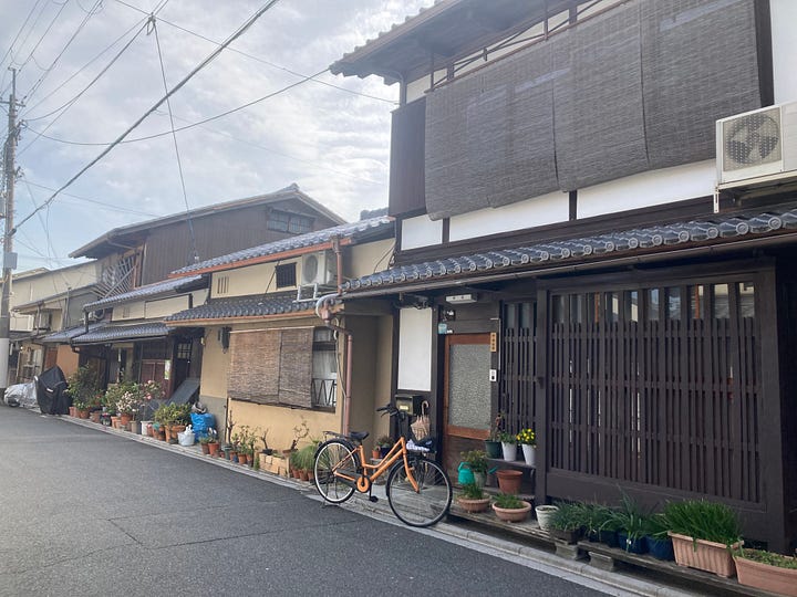 4 images: A sakura tree, a giant pumpkin by Yayoi Kusama, a room full of mirrors and metallic eggs, and a quiet street in Kyoto.