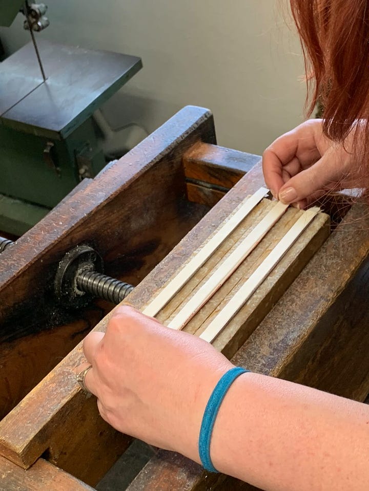 A series of images that show a person being taught how to stitch and glue paper to make a notebook