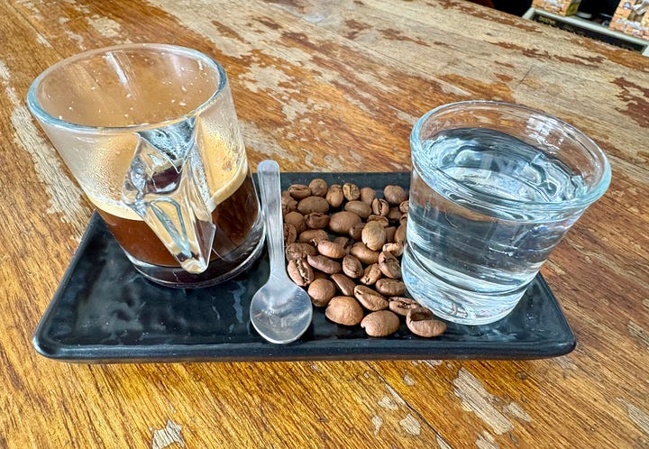 El dueño de Coati´s Coffee Shop explicándome la "mística" del buen café mientras lo pesa y así sirve el expreso, con agua para limpiar paladar y cucharilla para mezclar sabores y aromas. Foto propia.