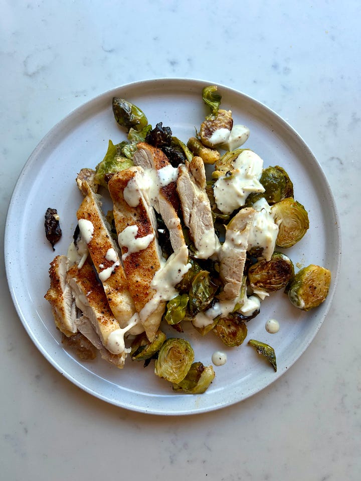 Brussels sprouts on a sheet pan and a photo of warm Brussels sprouts with caesar inspired dressing.