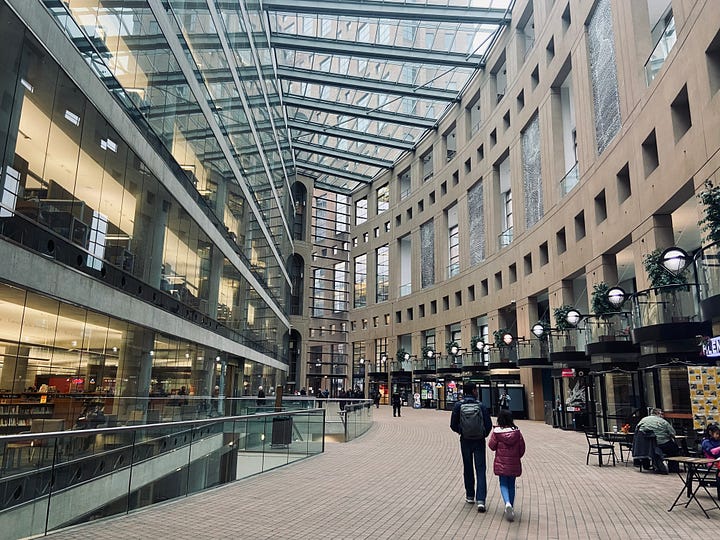 Left: man and girl in front of Vancouver Public Library. Right: In the walkway inside the library, with tall glass and steel ceiling.