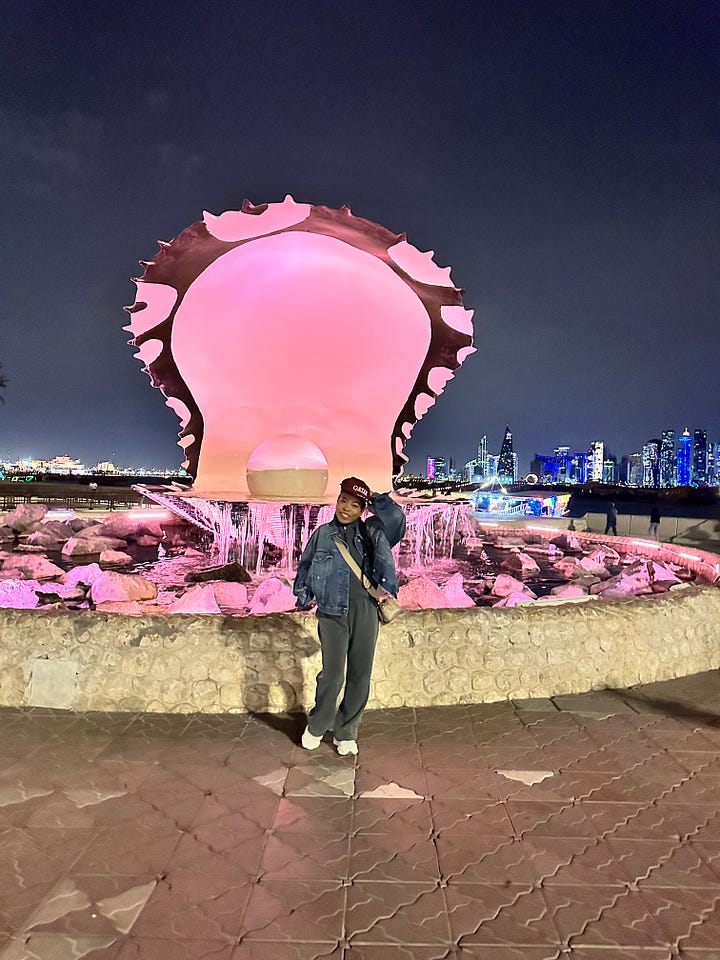Woman posing in front of The Pearl, Doha Qatar