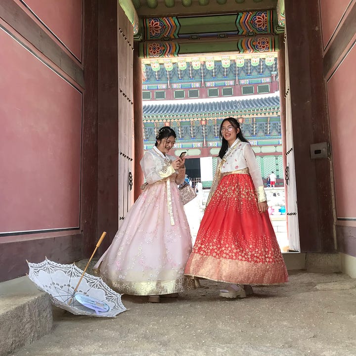 Visitors to the Gyeongbokgung palace in Seoul dressed in traditional Hanboks