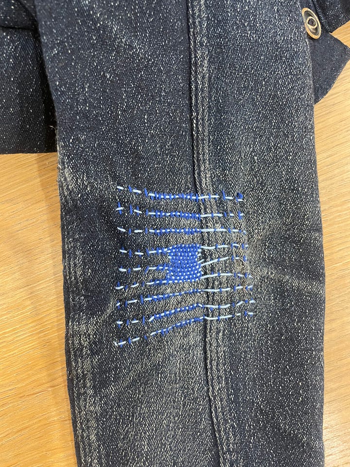 Two examples of darning, one on the knee of pants and the other on the elbow of a jacket 