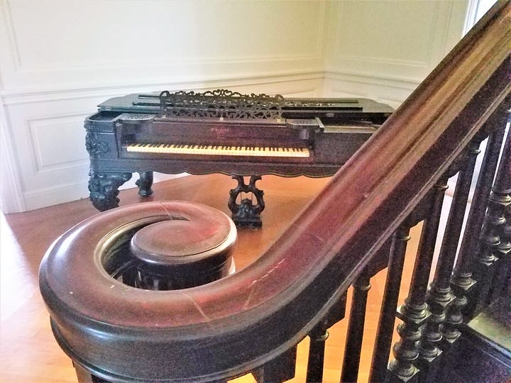 An old piano and beautiful wooden staircase at Laburnum.