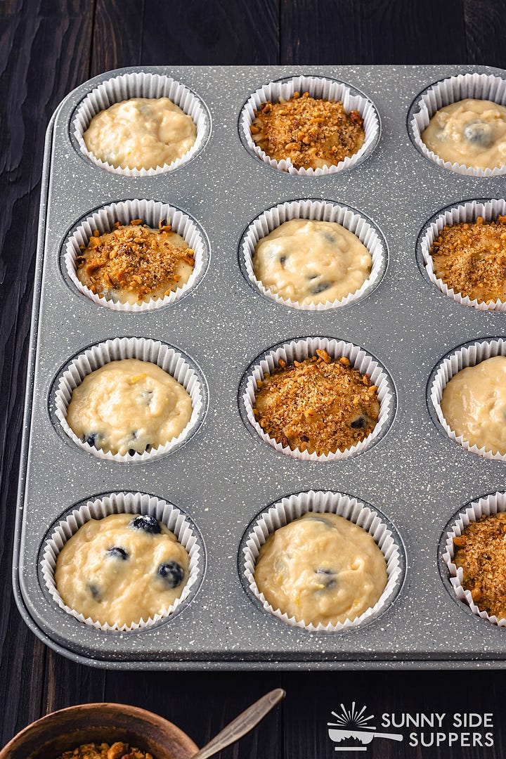 Making blueberry muffins in a muffin tin.