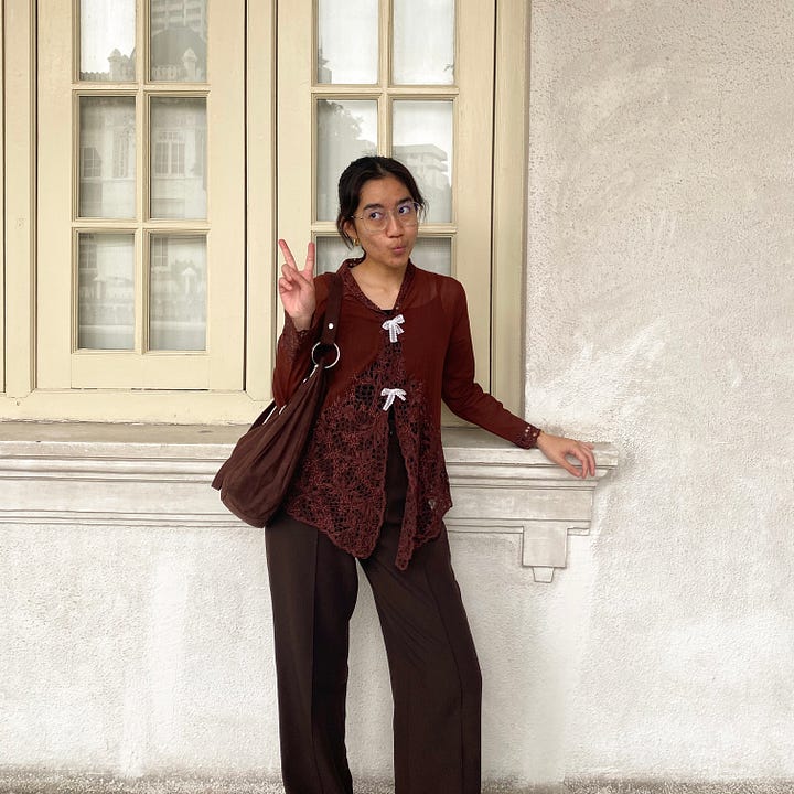 Author wearing a brown kebaya top with brown pants and bag and golden slingback flats.
