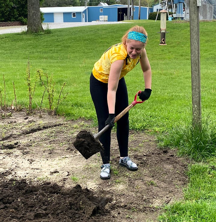 Author's young adult daughters helping her father plant a garden.