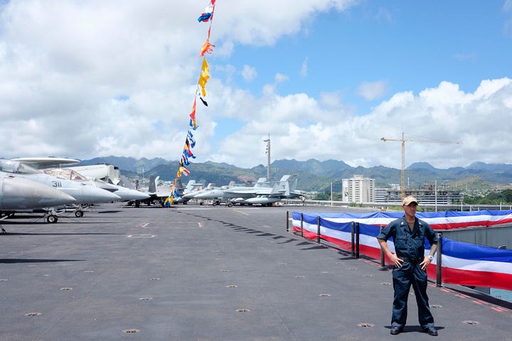 In-port naval open house images including a press conference. One image of the USS Carl Vinson steaming out of Pearl Harbor as a passanger jet takes of at HNL.