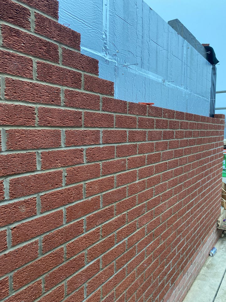 brick work down the side of the property and an opening for the window at the front