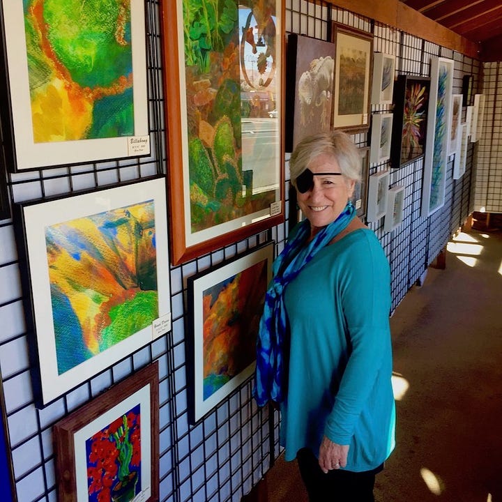 Photo of Artist Sherry Killam with her paintings in a gallery; "Eye in the Sky" painting by Sherry Killam Arts.