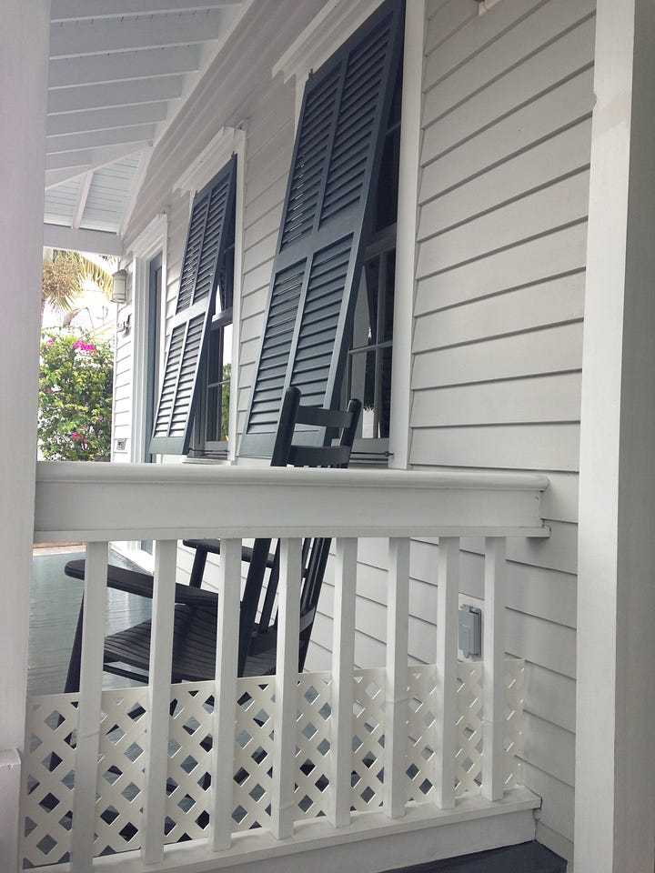 Weatherboard verandah with rocking chairs. 