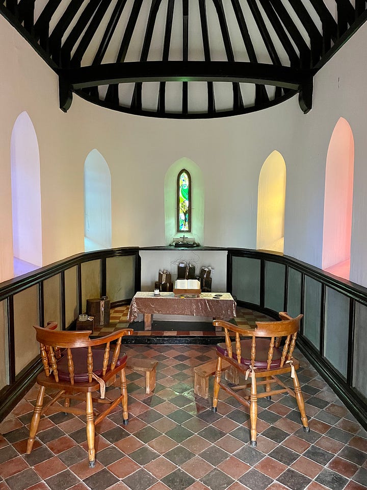 The first image shows the inside of a small chapel, rainbow light shining through from the stained glass window. The room contains a tiled floor, plain white walls, two wooden chairs, a small altar, candles, Bible and written prayers. The second image is of St. Beuono's Jesuit Spirituality Centre, looking from above down a grassy hill at sunset.