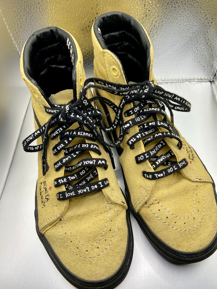 the front and back view of a pair of yellow suede Vans sneakers (a collaboration with A Tribe Called Quest).