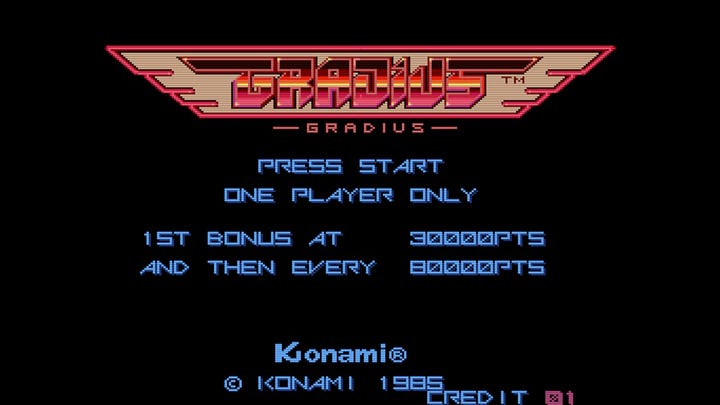 On the left, a screenshot of the Gradius title screen, which is a plain, black background with the winged Gradius logo at the top. Press Start, player number, extend info, and copyright fill the rest of the middle of the screen up. On the right, a screenshot of the title screen for the North American version of Gradius, titled Nemesis, which is the same as the Gradius screen, except the background isn't black: it shows the Vic Viper flying into the background, battling a giant ship. Moai heads shooting rings, planetary surfaces, and a star are also shown.