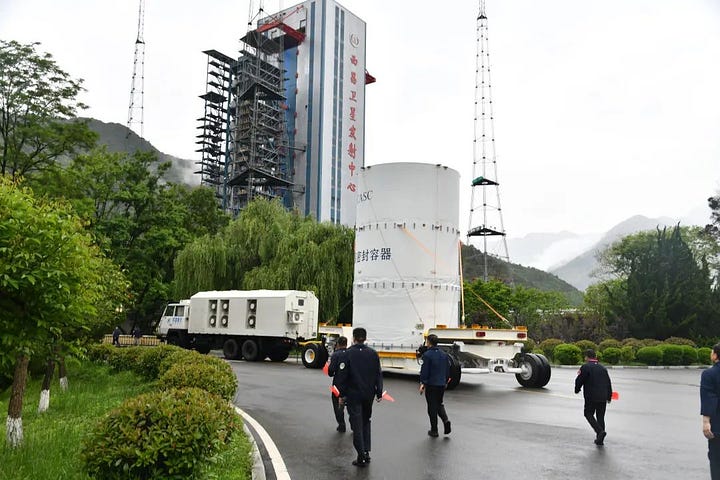 The Tianwen-2 probe, inside a protective casing, being lifted toward the top of the Long March 3B/E during launch preparations.