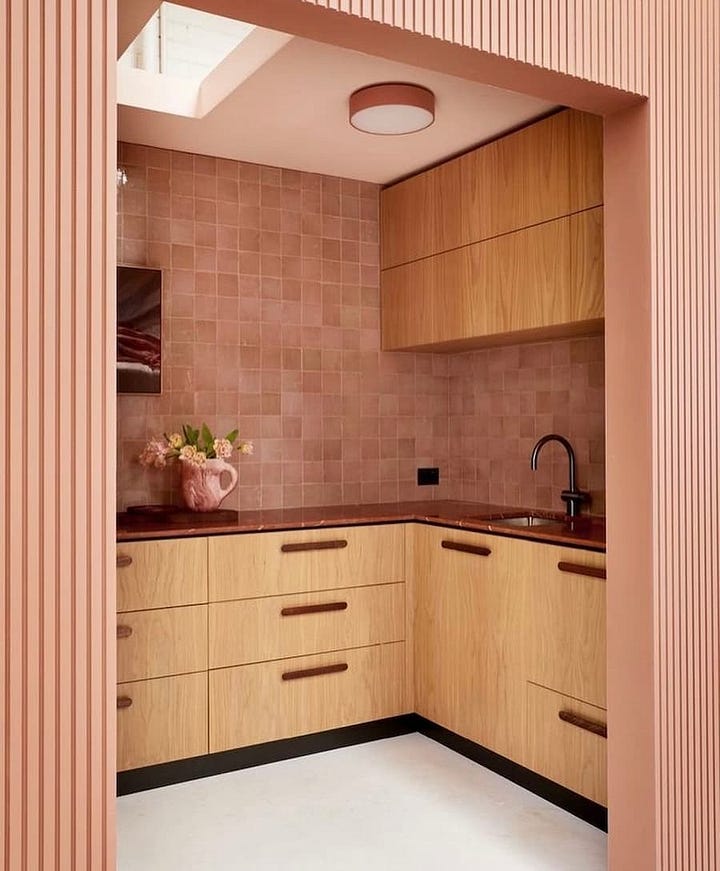 Peach Fuzz colour theme combined with beech wooden units for both a kitchen and bathroom 