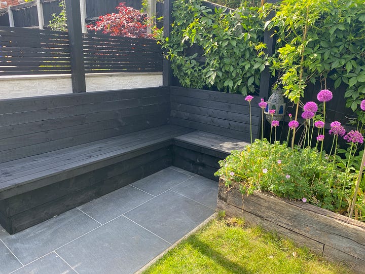 wooden slats added to the seating frame to create a seated area, one photo showing the initial process and the second showing it complete and painted in black