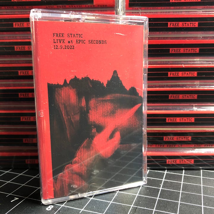 Free Static's new cassette release "Live at Epic Seconds 12.9.2022" pictured on a shelf at Epic Seconds, and in a stack on my drawing table.