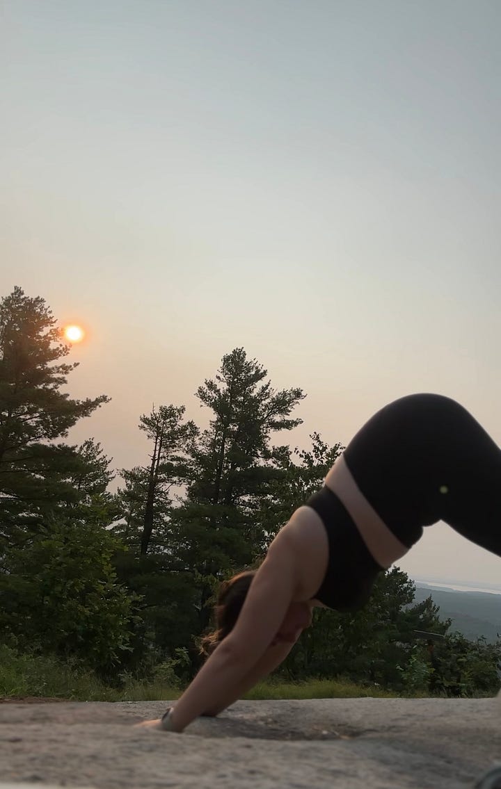 A gallery of images shows a woman standing on a mountain top with the rising sun in the background doing a series of yoga poses.