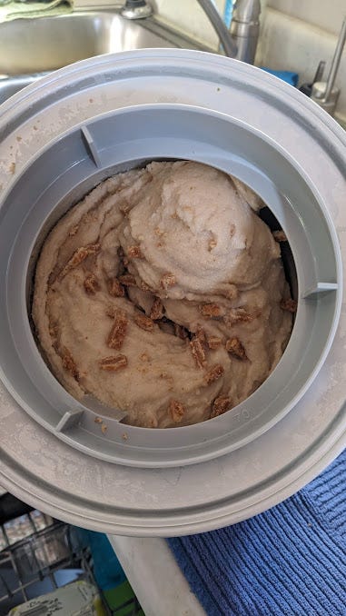 2 photos of ice cream in the maker: one of orange pumpkin spice and one of pale pancake flavor with bits of stroopwafel
