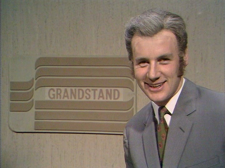 A chalkboard VT clock, followed by Michael Palin as Frank Bough looking very amused at Eric Idle's dirty joke