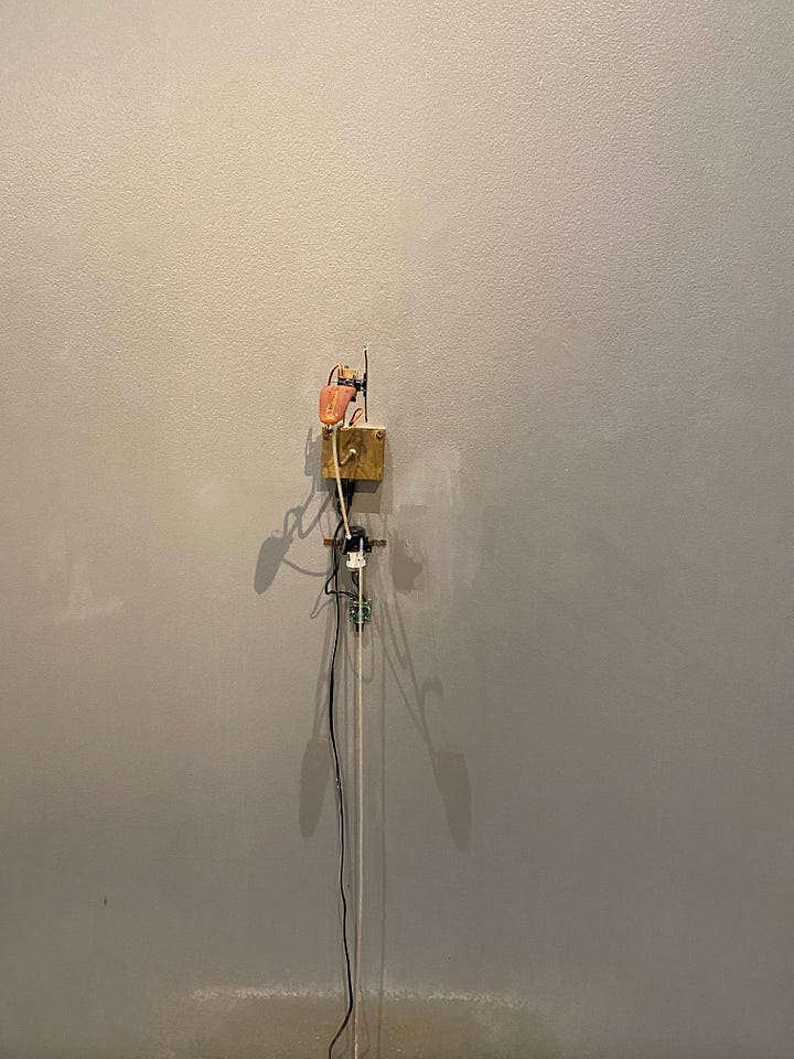 On the left is a series of screens depicting different examples of visual ASMR, on the right is a piece of artwork by Tobias Bradford: a mechanical tongue attached to the wall that drips water