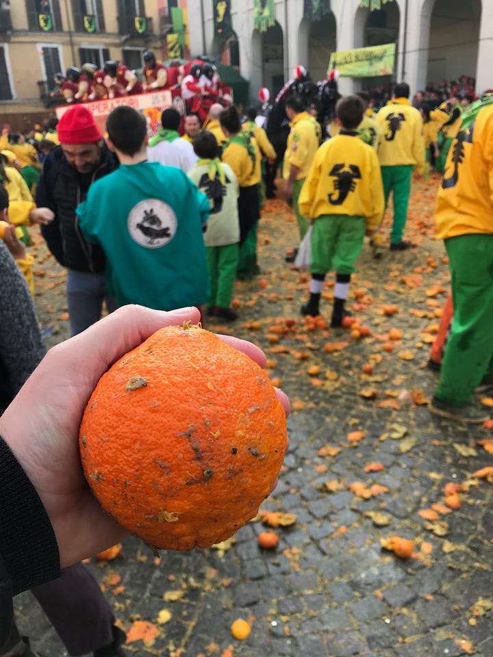 People throwing oranges, others resting after the throwing has finished, a hand holding an orange. All taken in Ivrea.