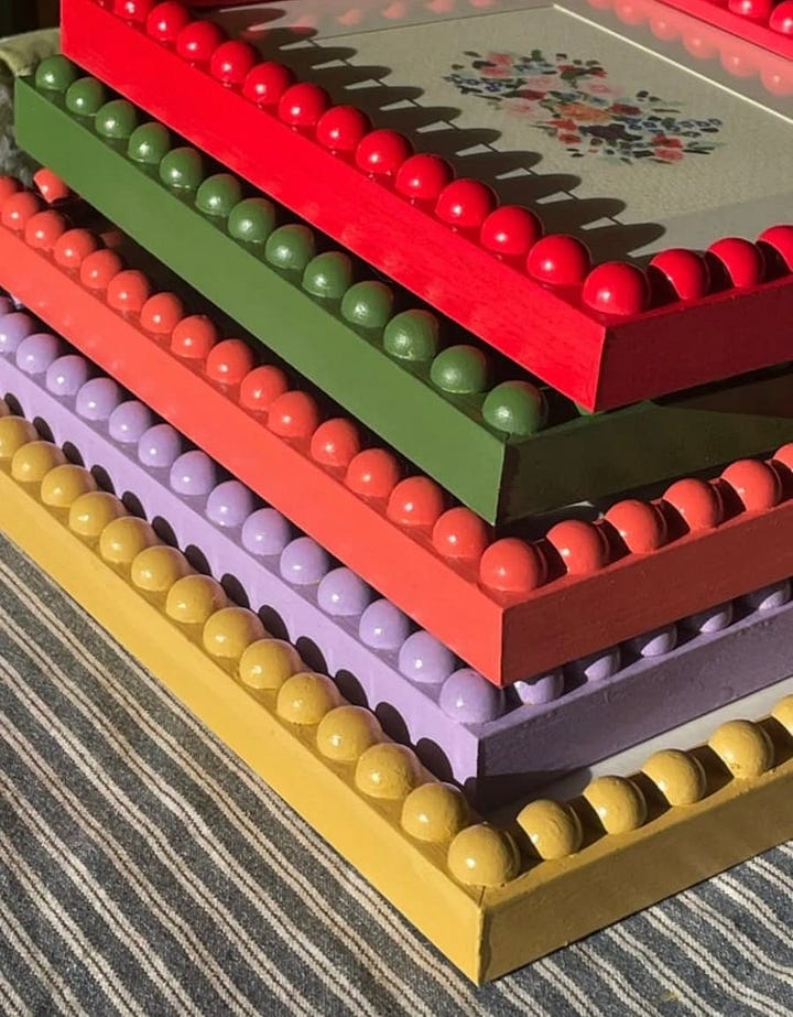 Selection of brightly coloured picture frames with small circle bobbins positioned around the edge