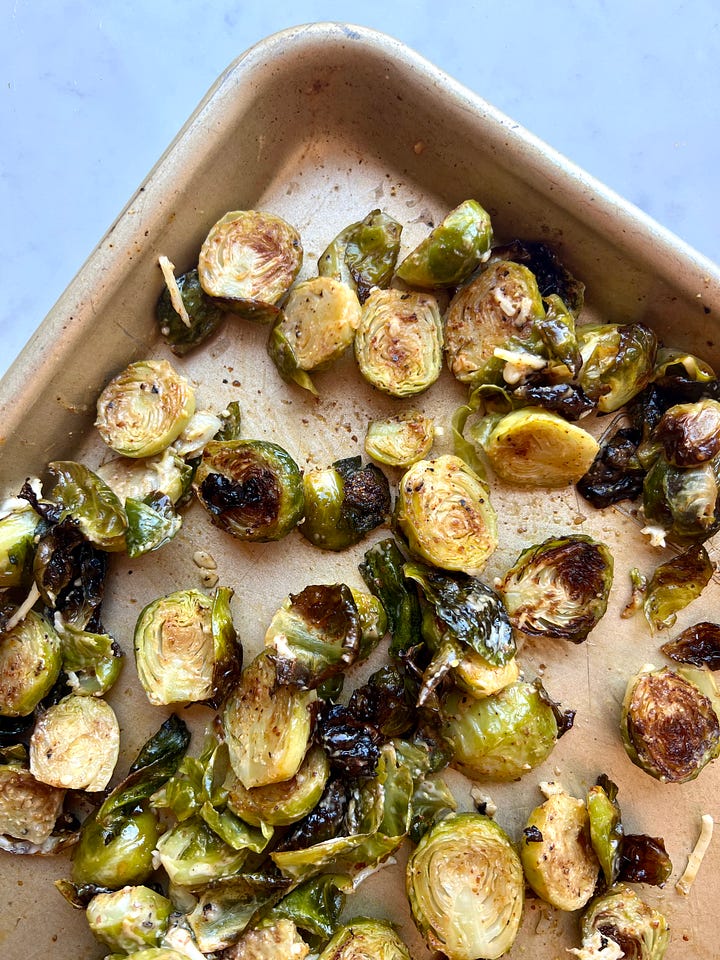 Brussels sprouts on a sheet pan and a photo of warm Brussels sprouts with caesar inspired dressing.