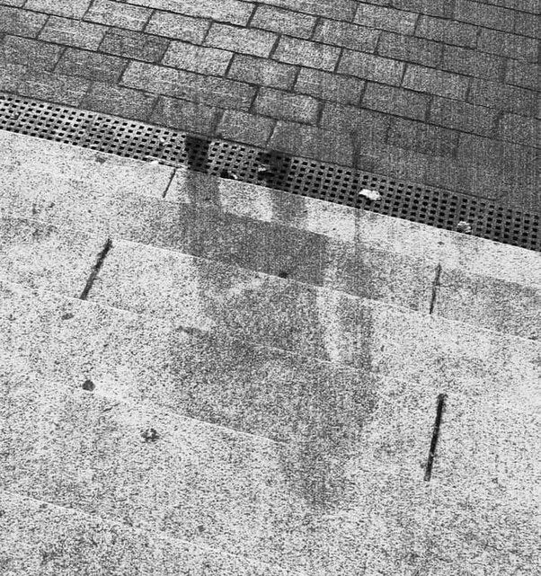 A burnt toddler tricycle; blast shadow left by a man on the steps of the bank